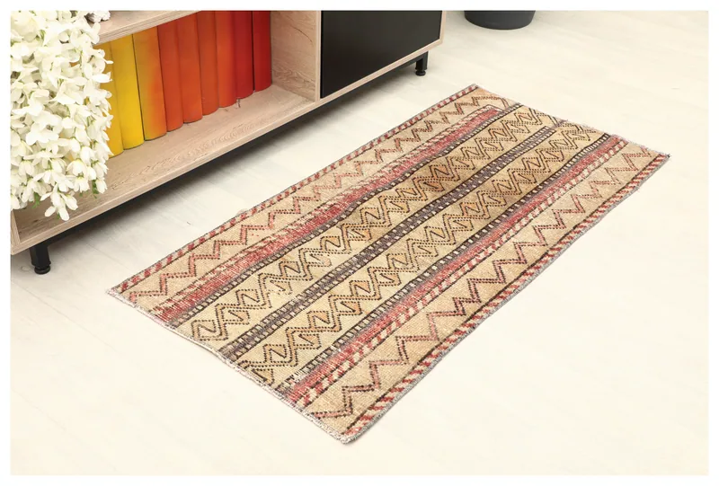 Full top view of the beige and rust tribal striped Anatolian rug on a white background.