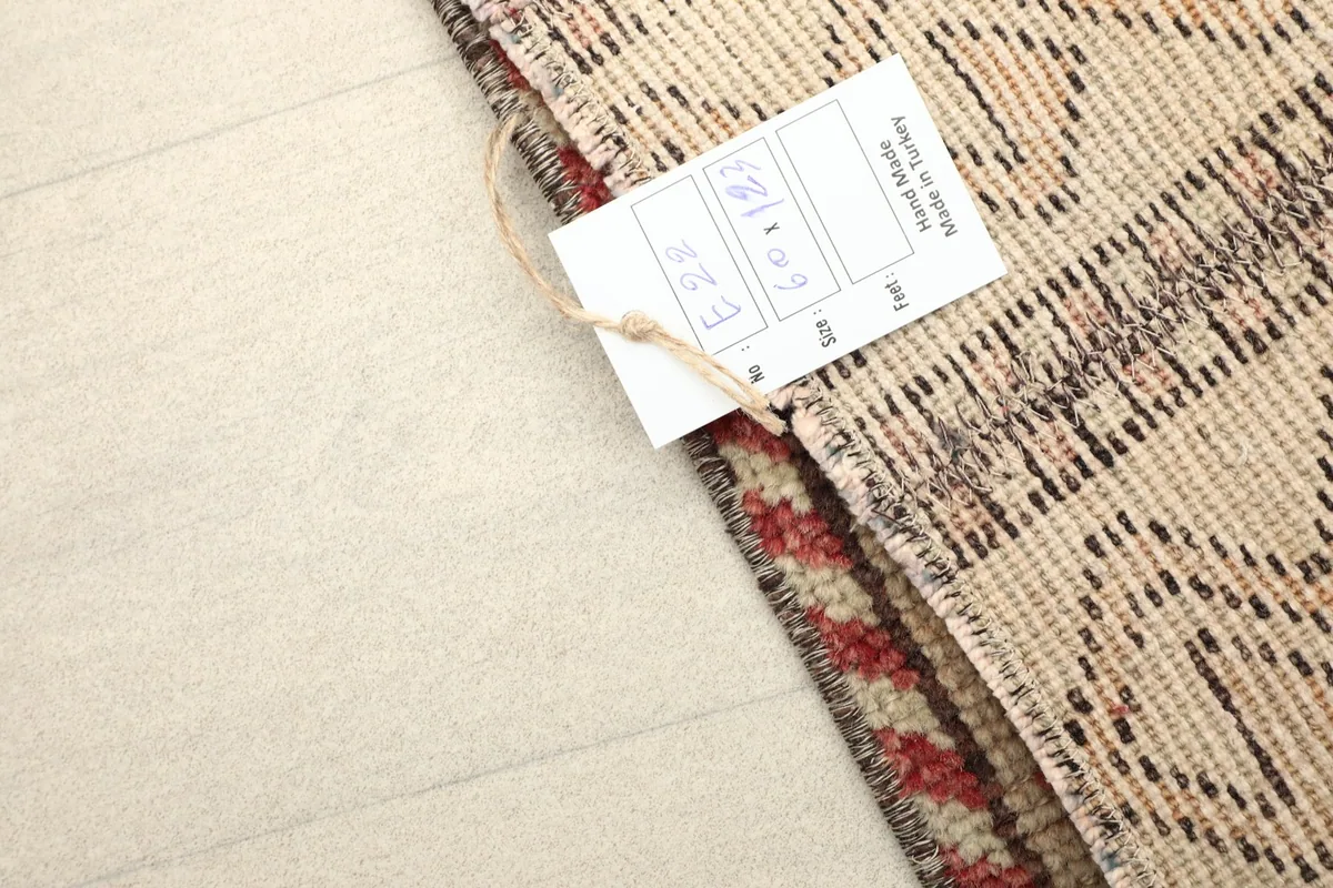 Detail of the rug's back with a product tag, indicating its hand-made origin in Turkey.