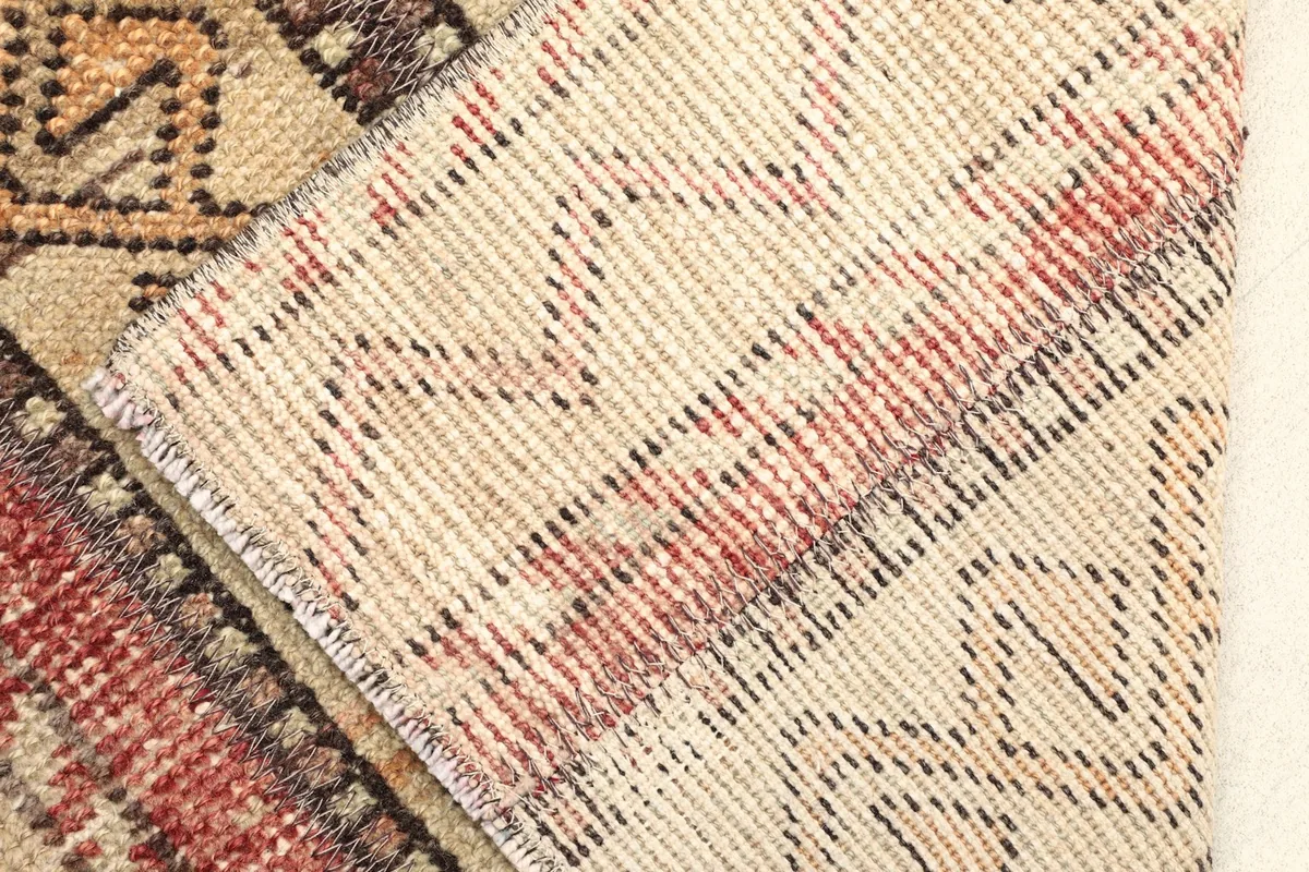 Close-up of the rug's reverse side, revealing the cotton foundation and hand-knotted construction.