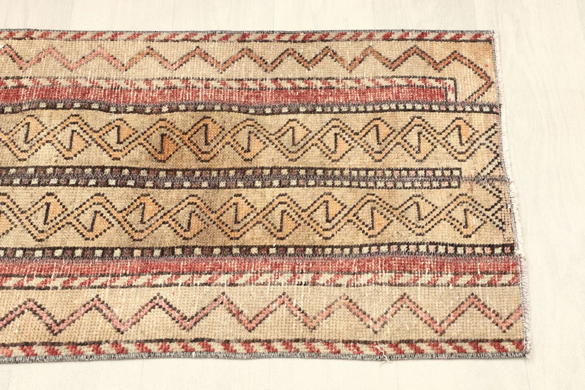 View of the opposite end of the rug, displaying the consistent tribal patterns and colors.