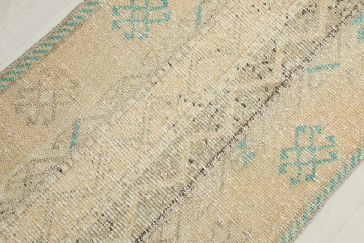 Close-up of the low pile and hand-knotted wool texture, showing visible wear and subtle patterns.