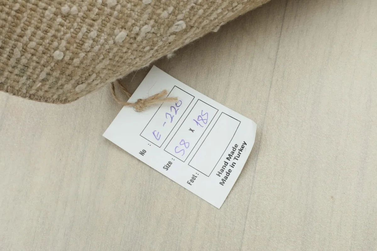 Close-up of the product tag attached to the rug, displaying its size in centimeters.