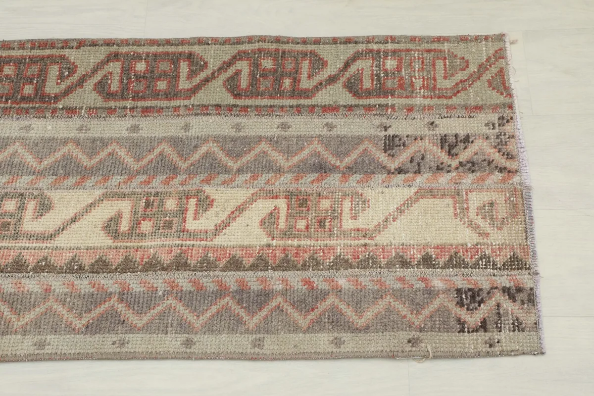 Close-up of one end of the rug, showing the tribal motifs and color variations.
