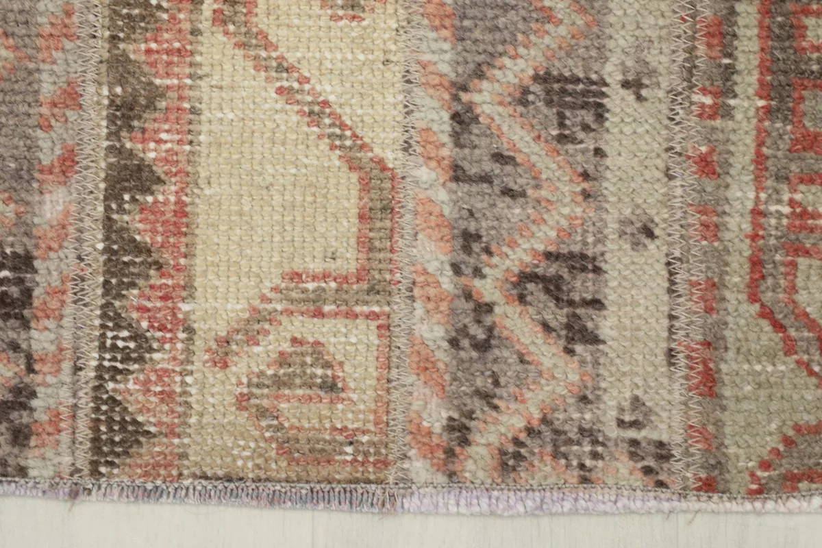 Close-up of the rug's edge, revealing the intricate weaving and colors.
