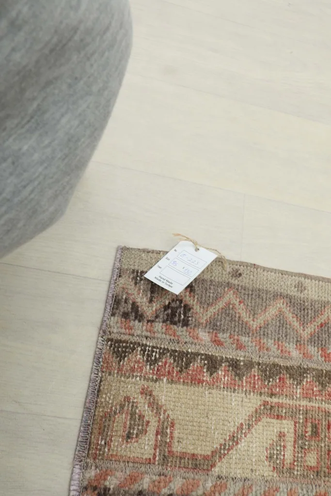 Close-up of the rug with its product tag, showing the texture and colors.