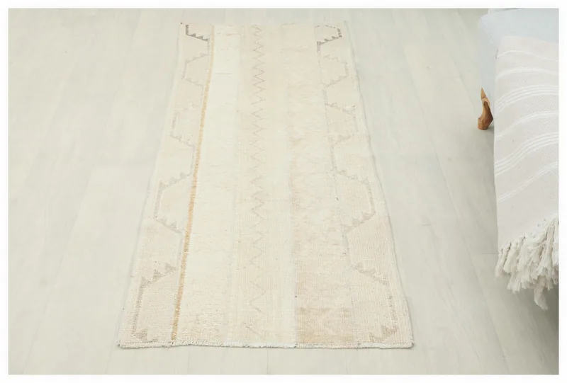 Full overhead view of a 2'1" x 5'5" beige and tan vintage Anatolian runner rug on a white background.