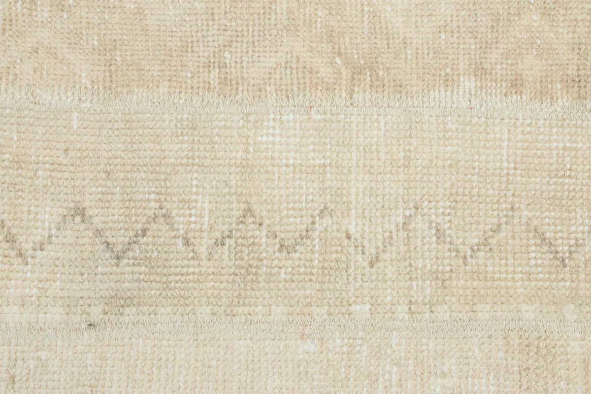 Detailed view of the central geometric zigzag pattern within the beige and tan runner rug.