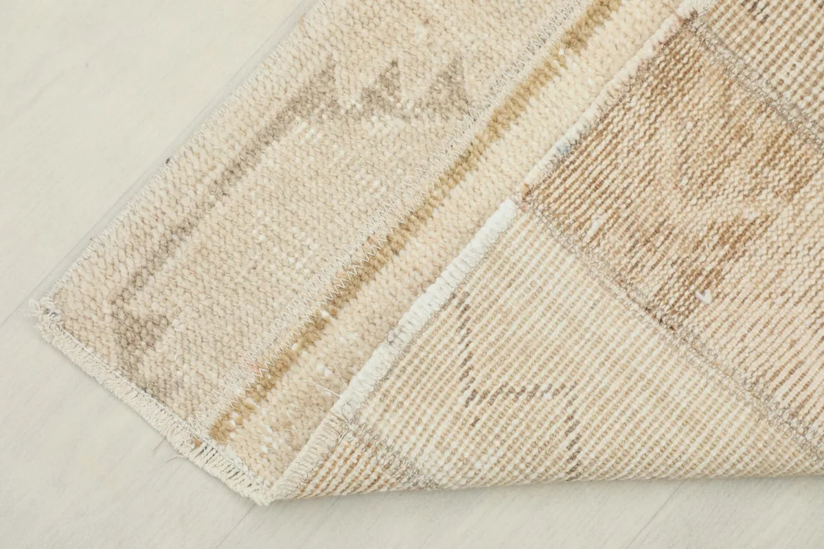 Corner of the rug folded to show the hand-knotted cotton foundation on the back.