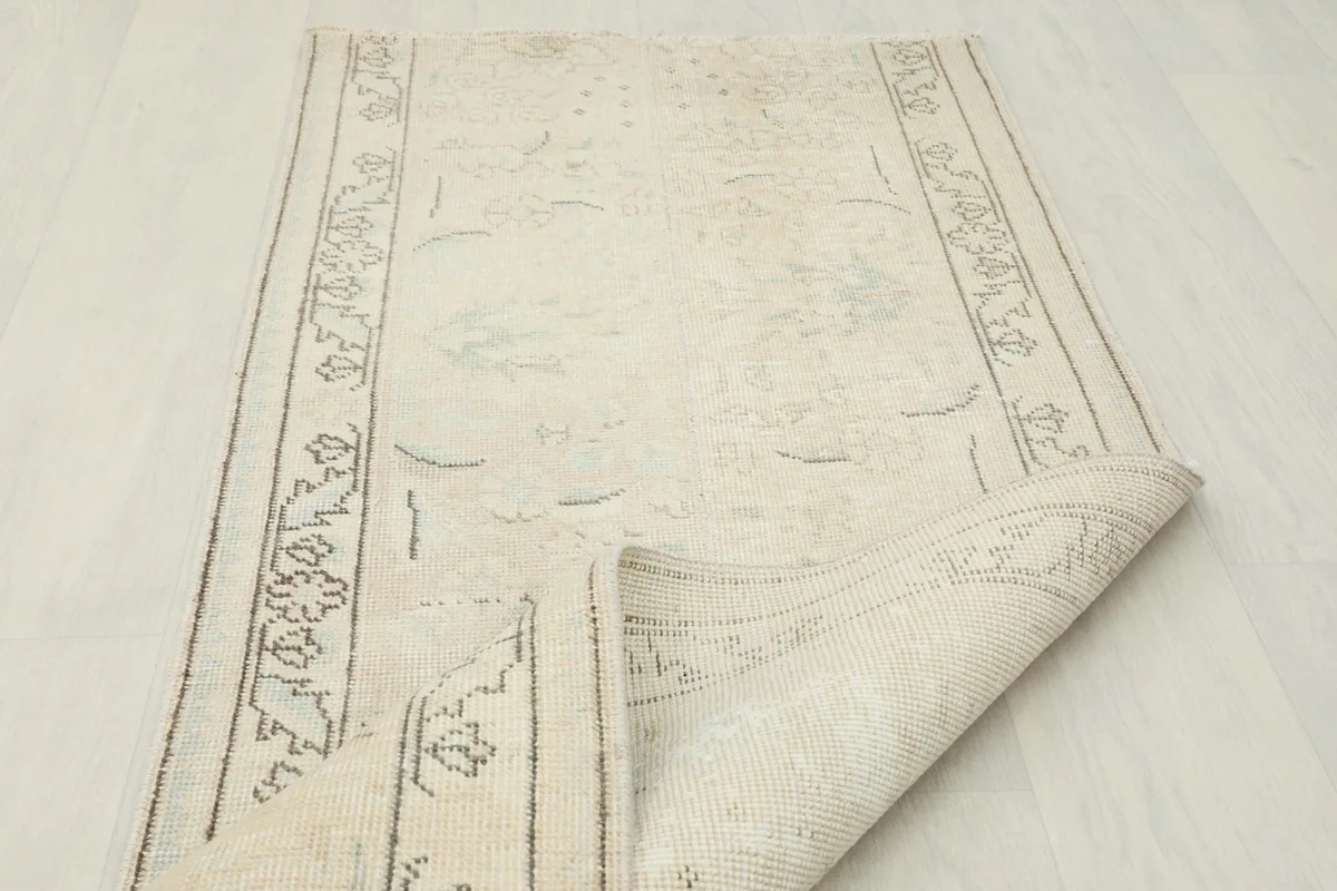 Runner rug partially rolled, displaying the flexibility of the vintage wool and cotton construction.