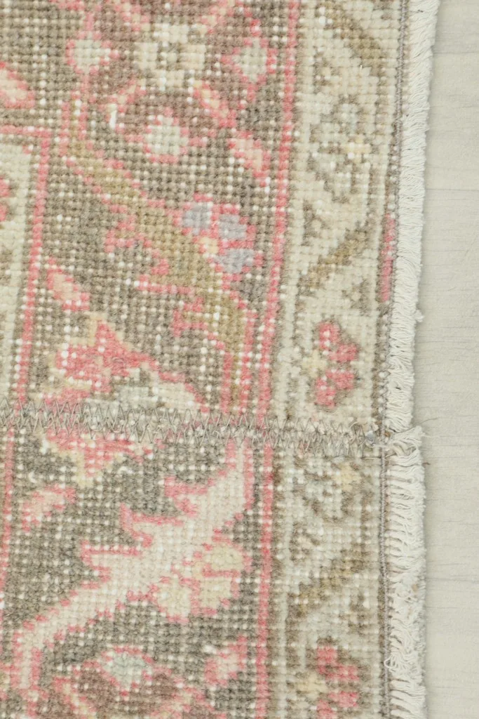 Close-up of the rug's finished edge, showing the border design and a small section of fringe