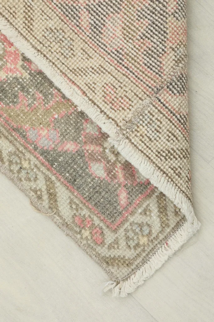 View of the back of the hand-knotted rug, revealing the cotton foundation and knotting