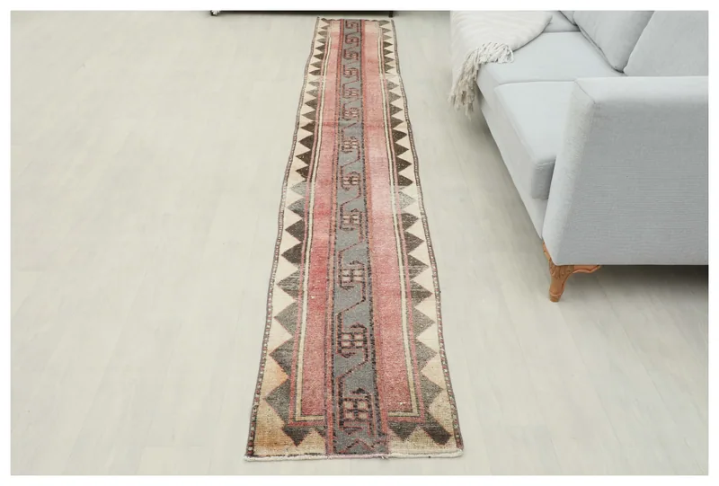 Full overhead view of the 1'9" x 11'10" rose and gray vintage Anatolian runner rug on a white background.