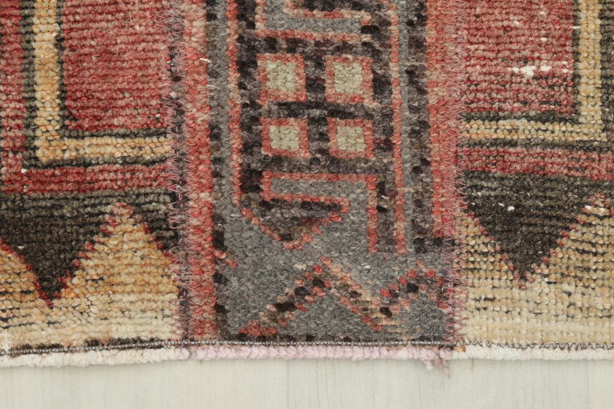 Close-up of the rug's edge, revealing the hand-knotted wool pile and the distinct border design.