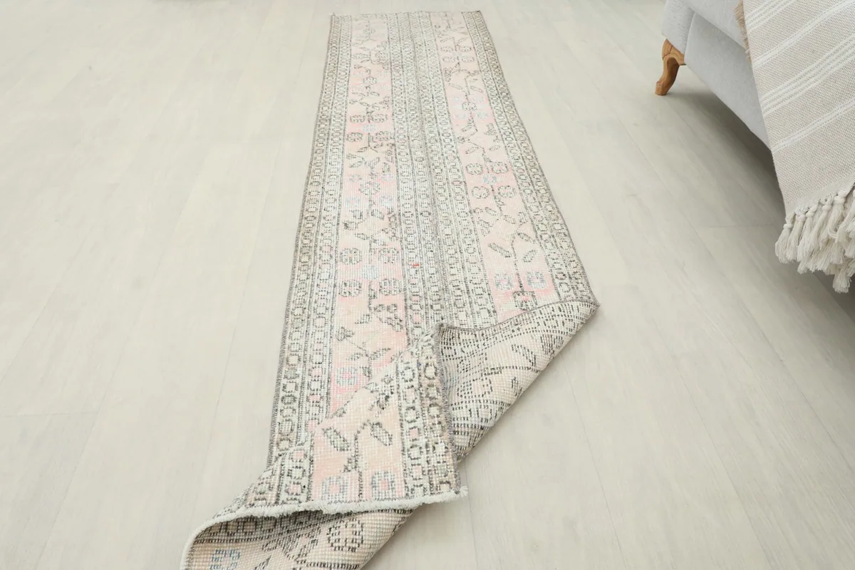 The runner rug partially rolled, demonstrating its flexibility and construction.