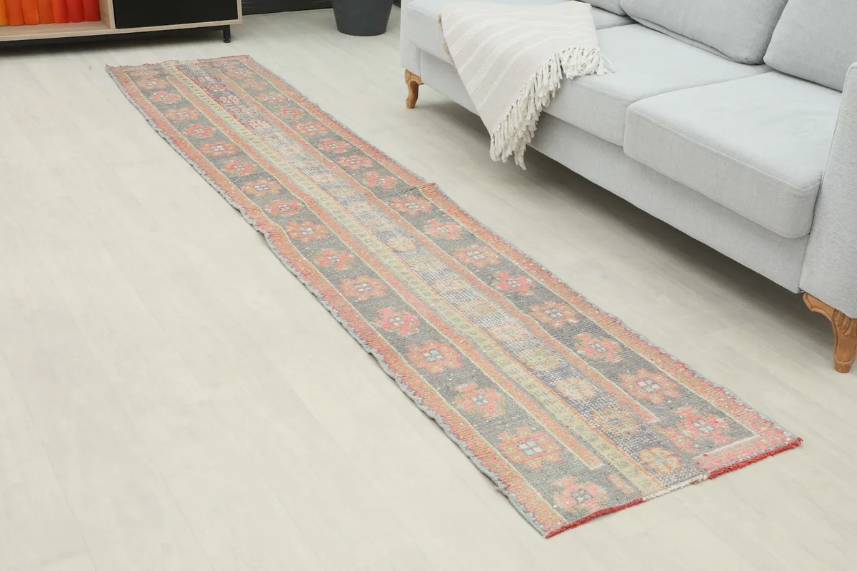 Angled view of the charcoal and rose runner rug showing its length in a room