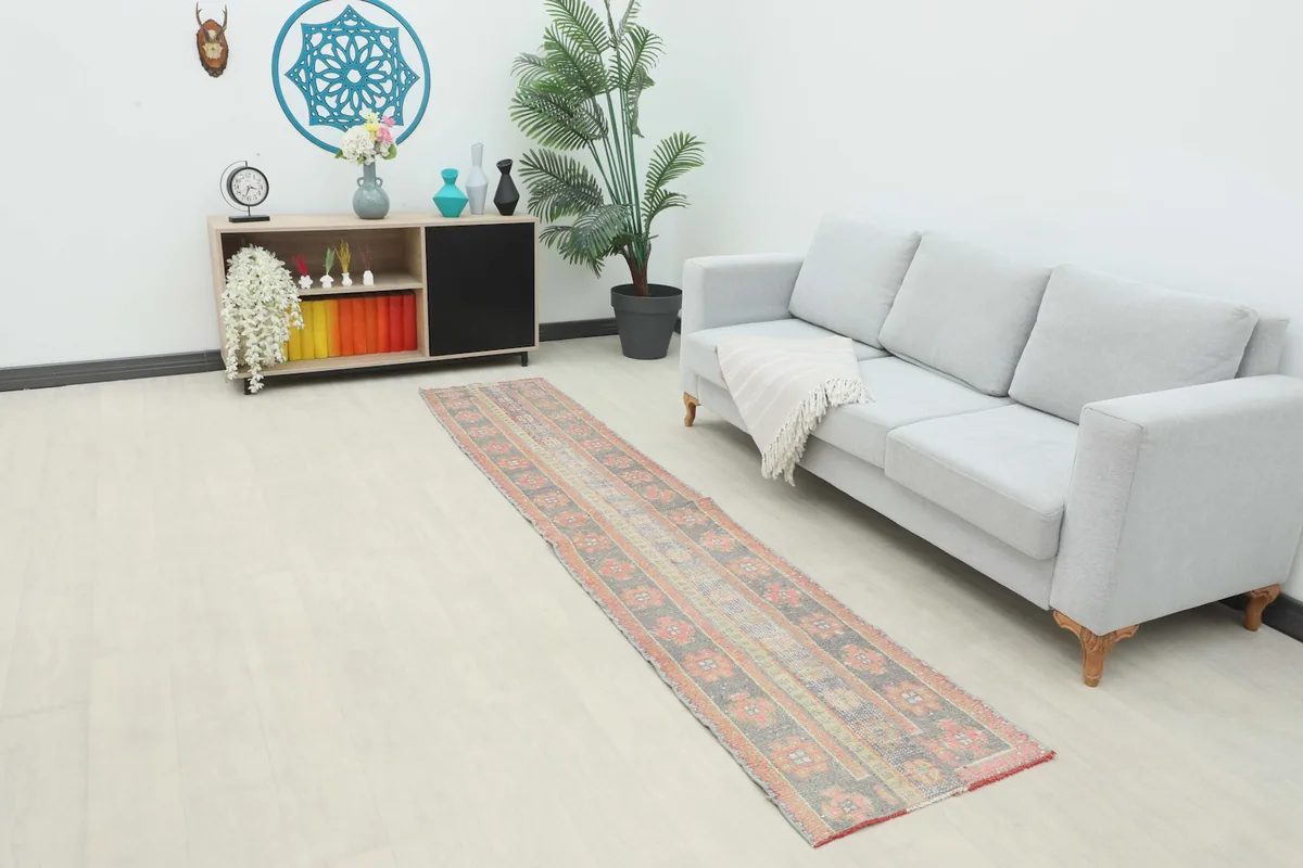 Runner rug displayed in a living room setting next to a light gray sofa and wooden console