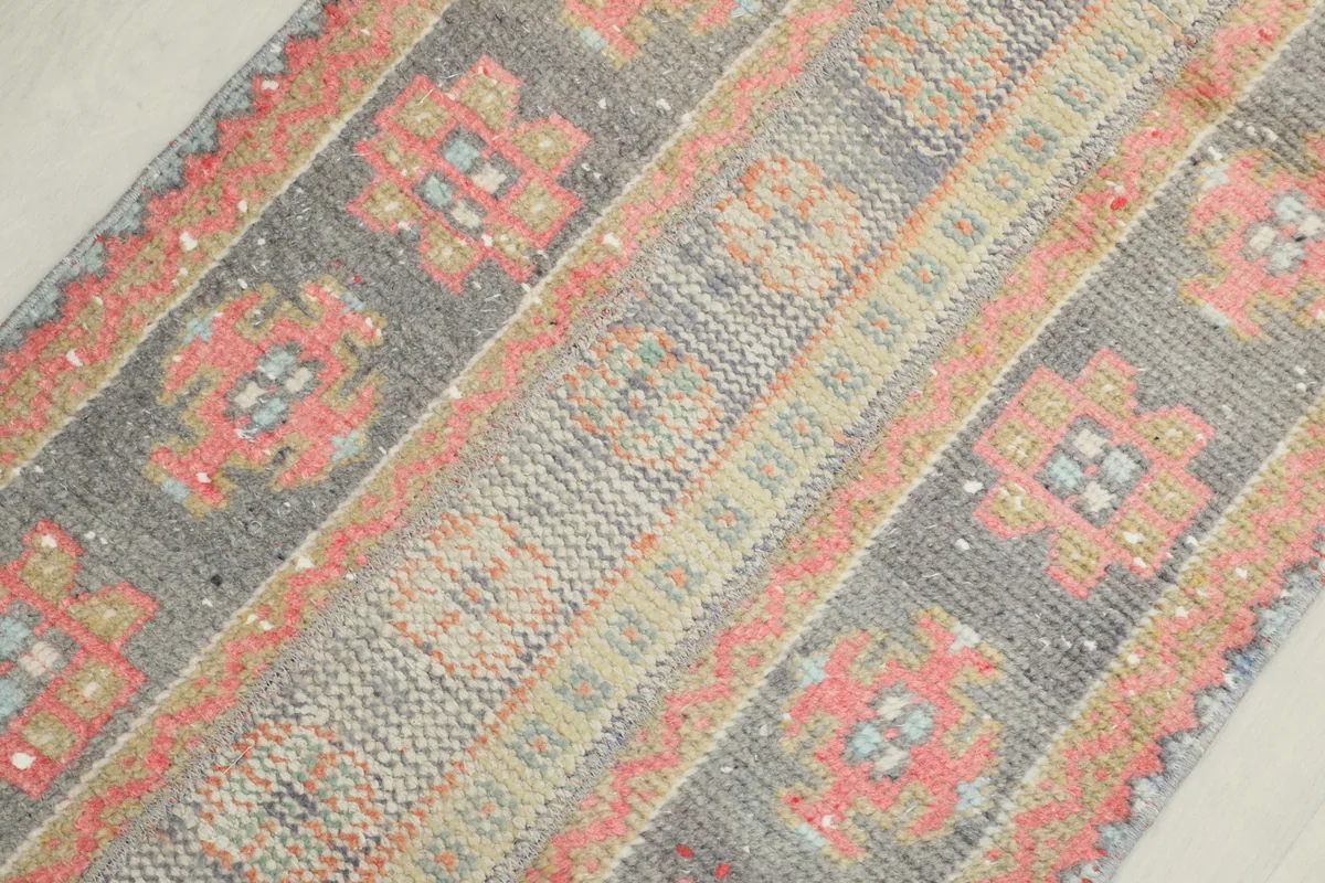 Detailed angled view of the rug's surface, highlighting the geometric patterns and colors