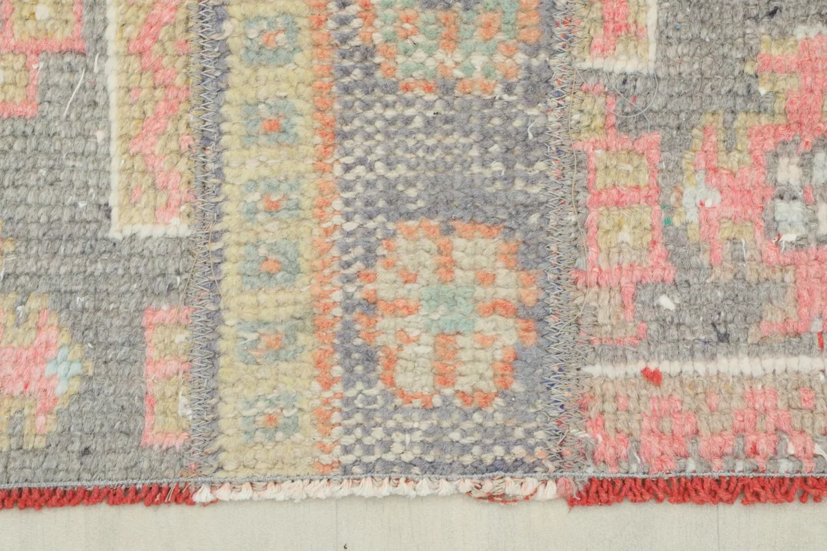 Detailed view of the rug's edge and fringe, showing the red binding and wool texture