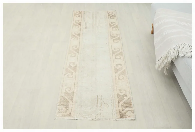 Full overhead view of the beige and tan geometric vintage runner rug on a white background.