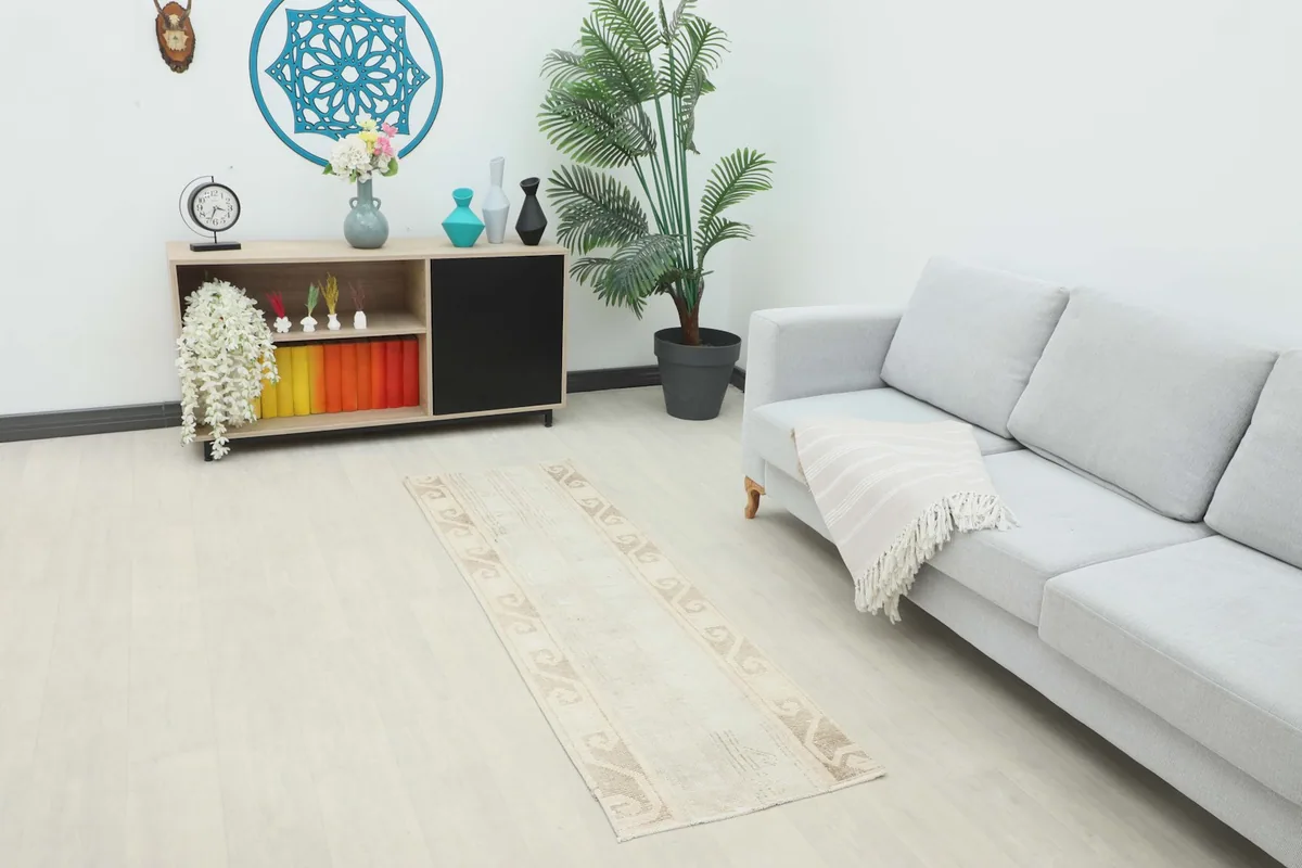 Vintage runner rug displayed in a modern room setting with a light gray sofa and wooden console.