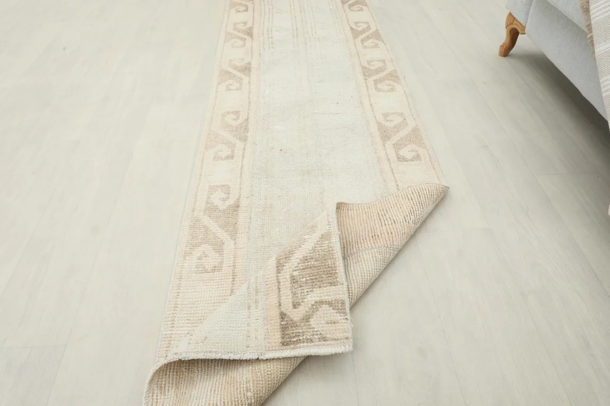 Rug partially folded to demonstrate its flexibility and the thickness of the wool pile.