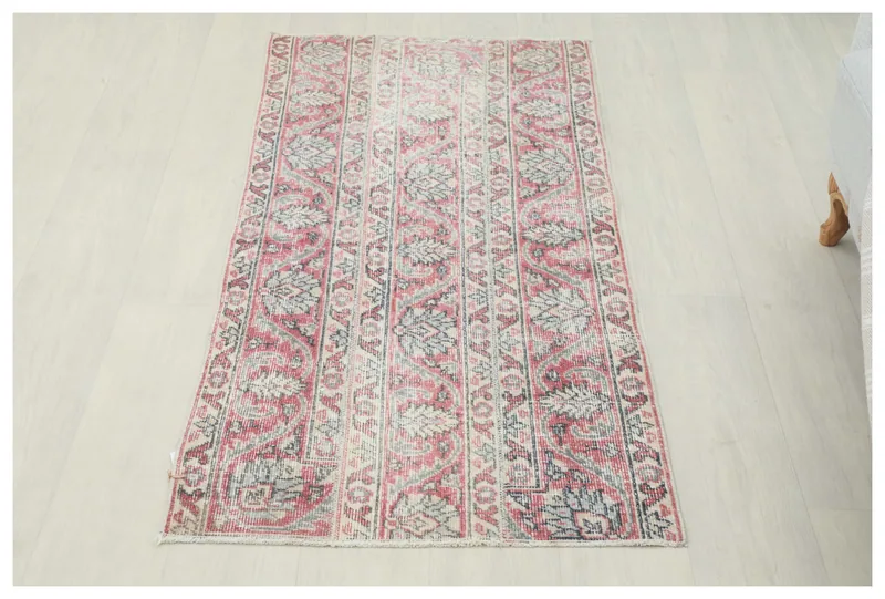 Full top view of the vintage rose and gray Anatolian area rug on a white background.