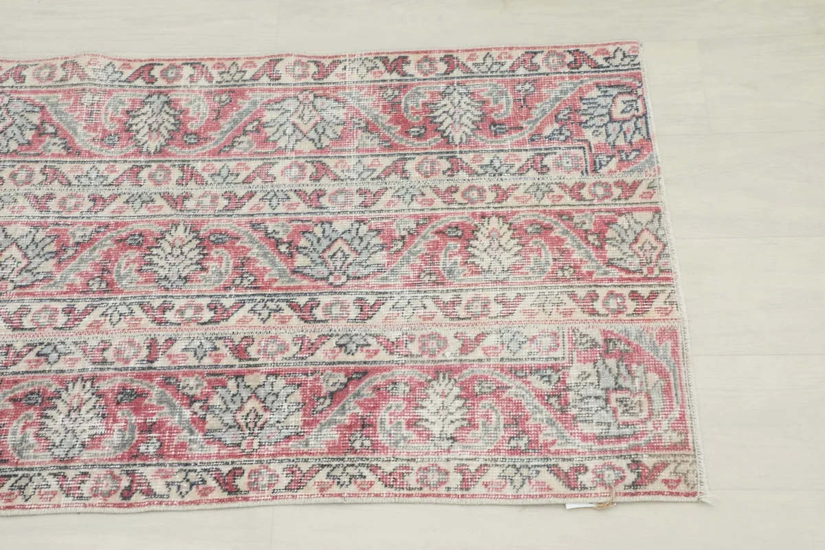 Close-up of the upper right corner of the rug, showing columnar floral and tribal patterns.