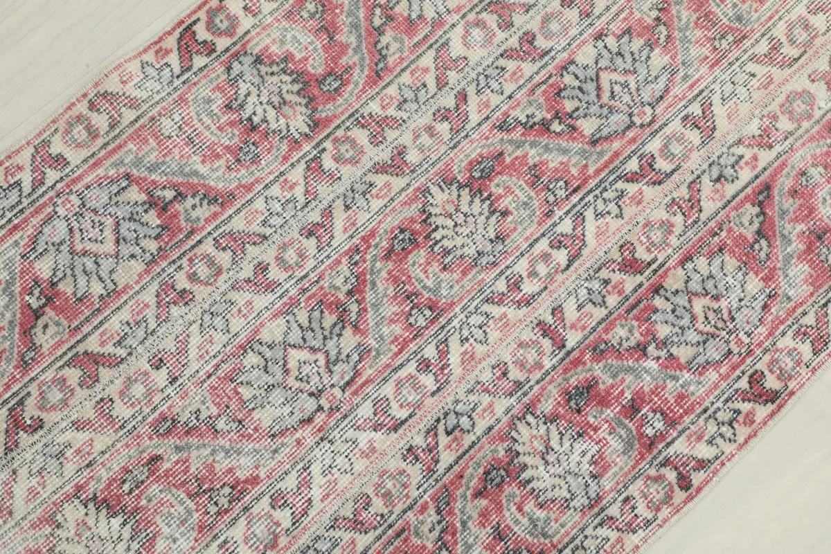 Diagonal close-up of the rug's surface, revealing the hand-knotted texture and motifs.