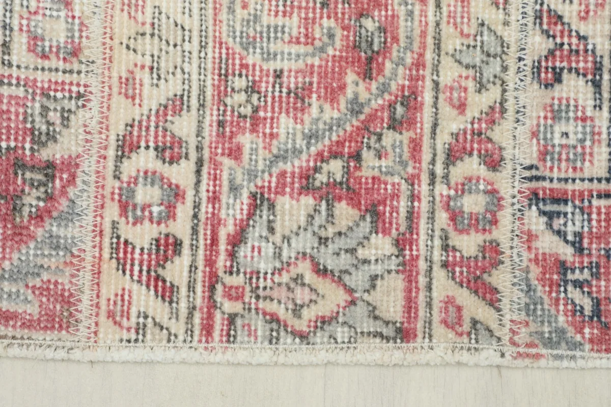 Close-up of the rug's edge, detailing the patterned border and fringe.