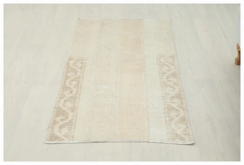 Full top view of the cream and tan geometric vintage Anatolian rug on a white background