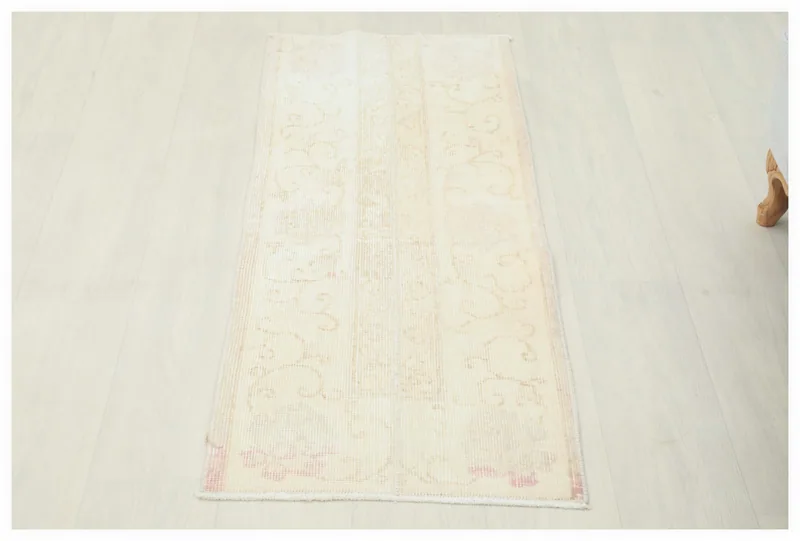 Full overhead view of the hand-knotted cream and rose Anatolian vintage rug on a white background.