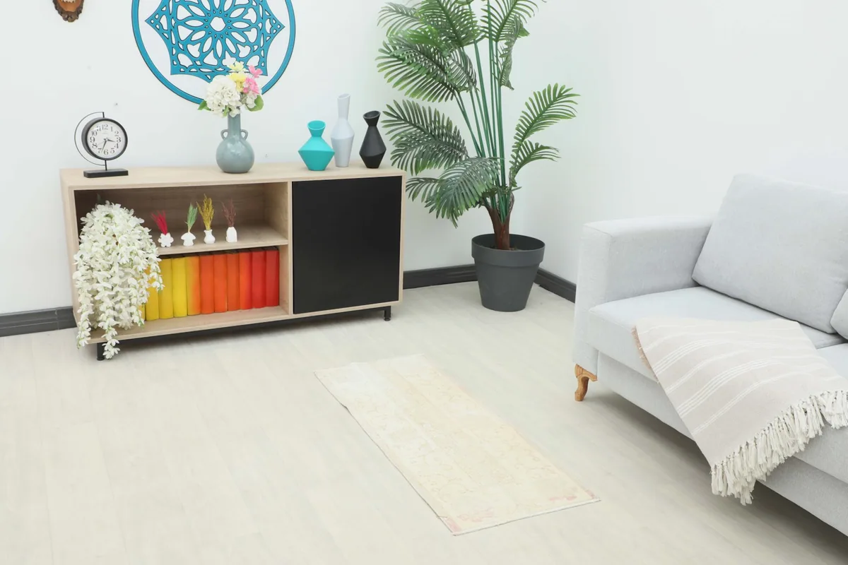 Vintage cream and rose rug placed in a modern living space with light flooring and furniture.