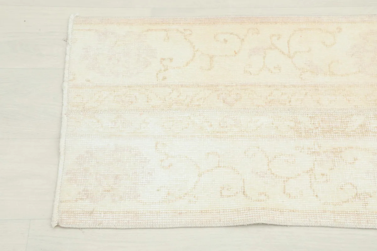 Detailed view of the rug's central design, showing the subtle geometric and floral patterns.