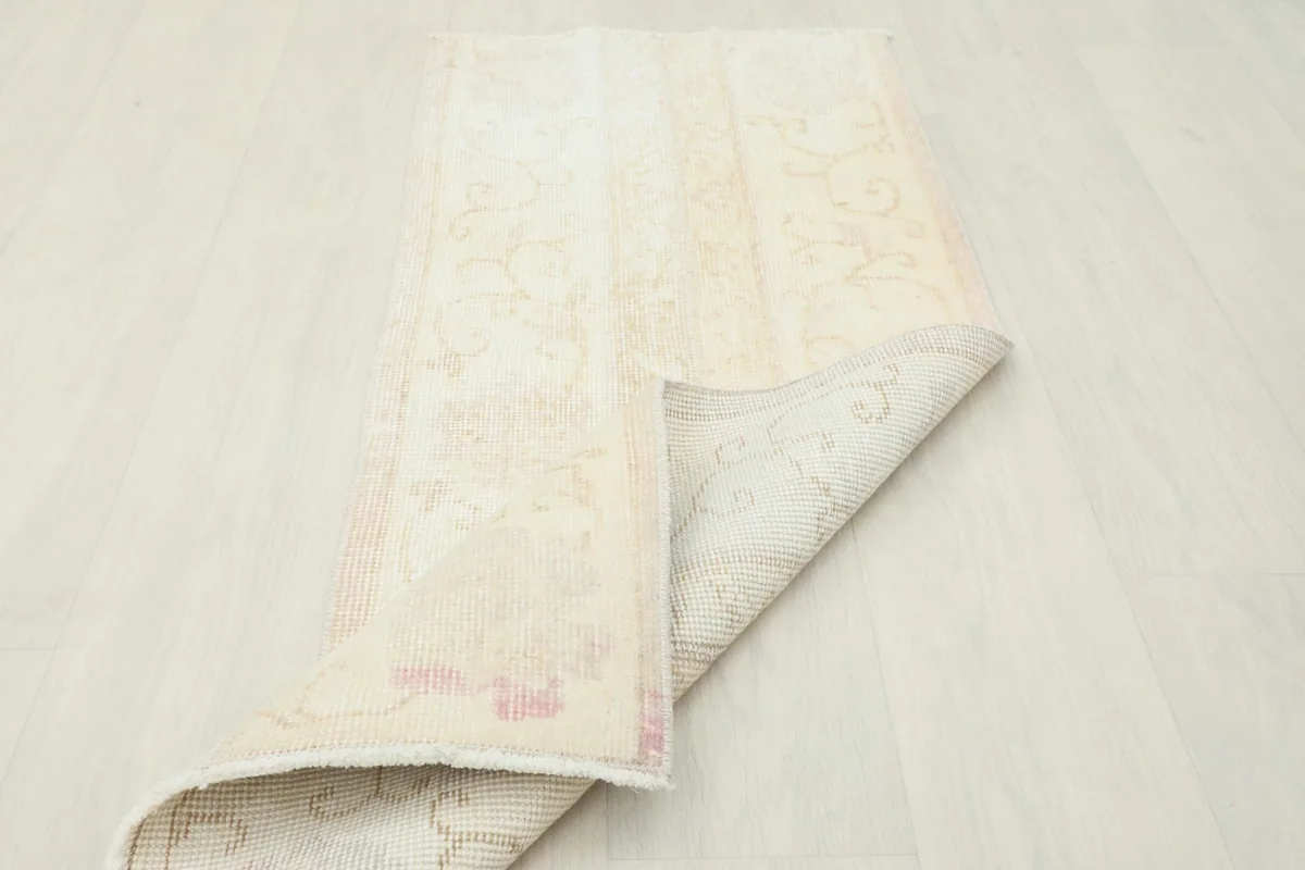Rug partially folded, displaying both the front pile and the sturdy cotton foundation.