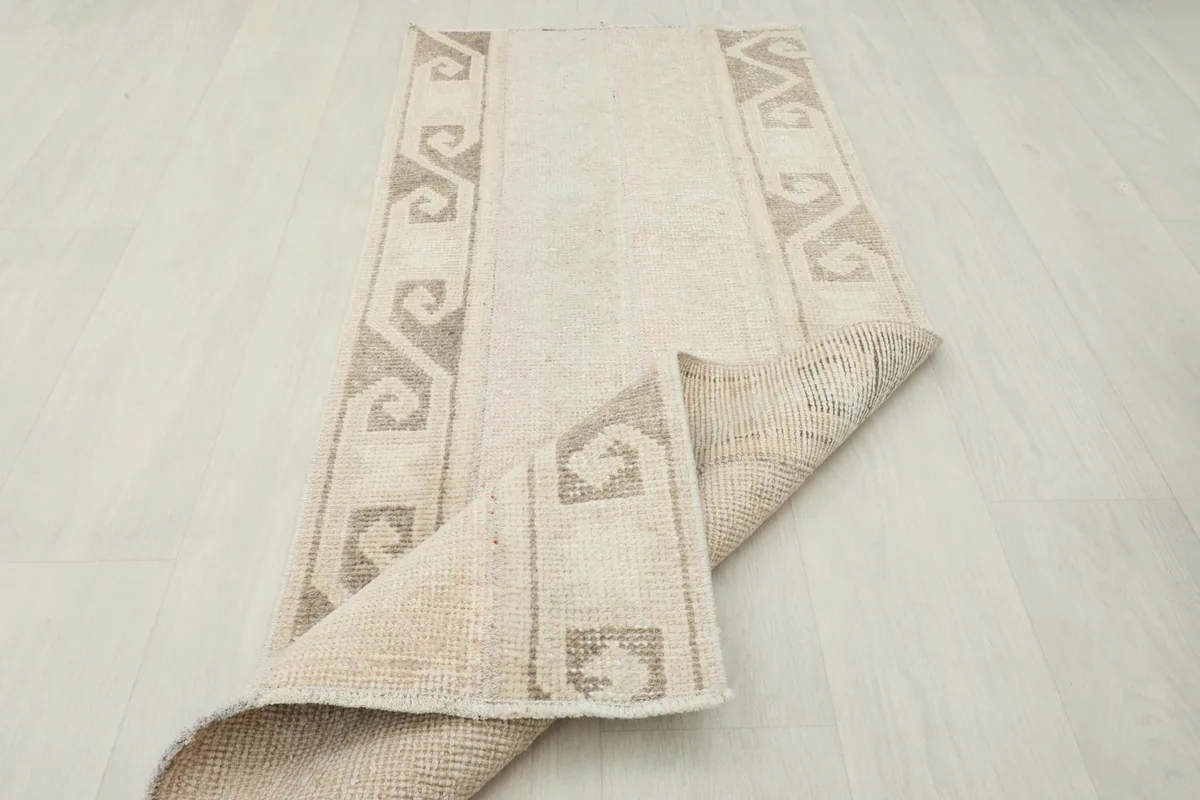 Corner of the rug folded back to show the back and front texture