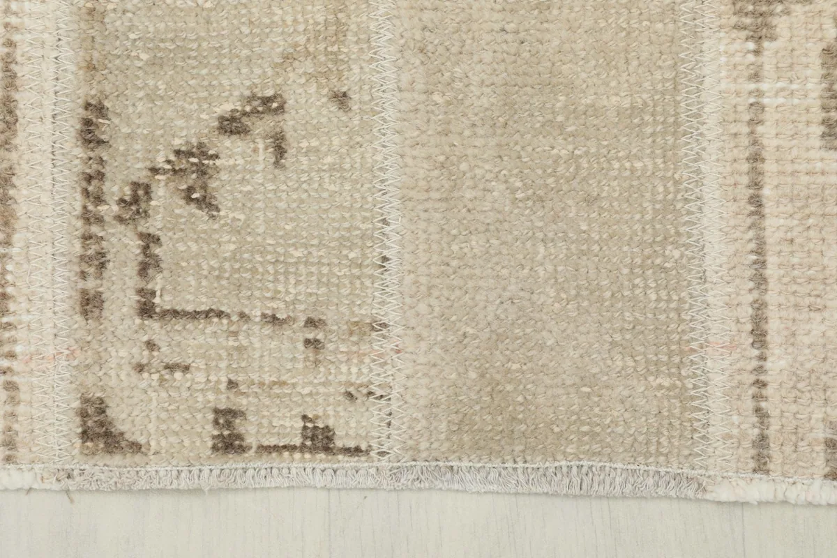 Close-up of a section of the runner showing natural wear and color variations in the beige and brown wool.