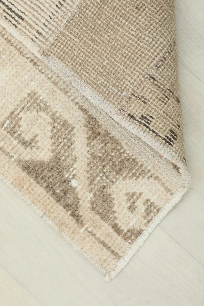 Corner of the runner folded back, revealing the reverse side and the hand-knotted construction.