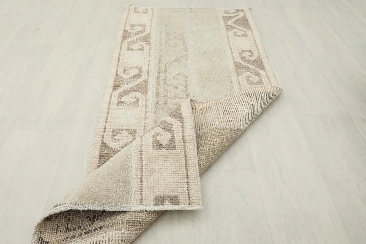 Runner partially folded, showing the cotton foundation and the back of the hand-knotted wool pile.