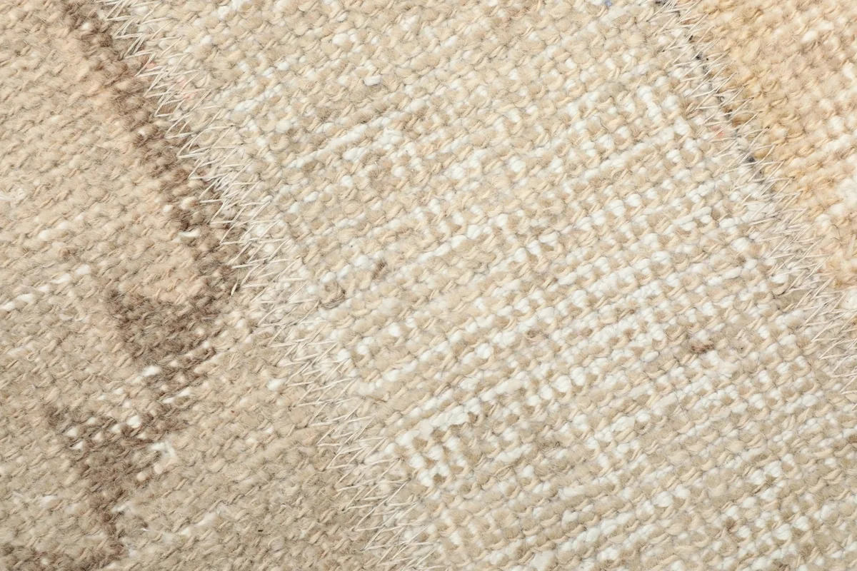 Extreme close-up of the low wool pile, showing the hand-knotted texture and fibers.