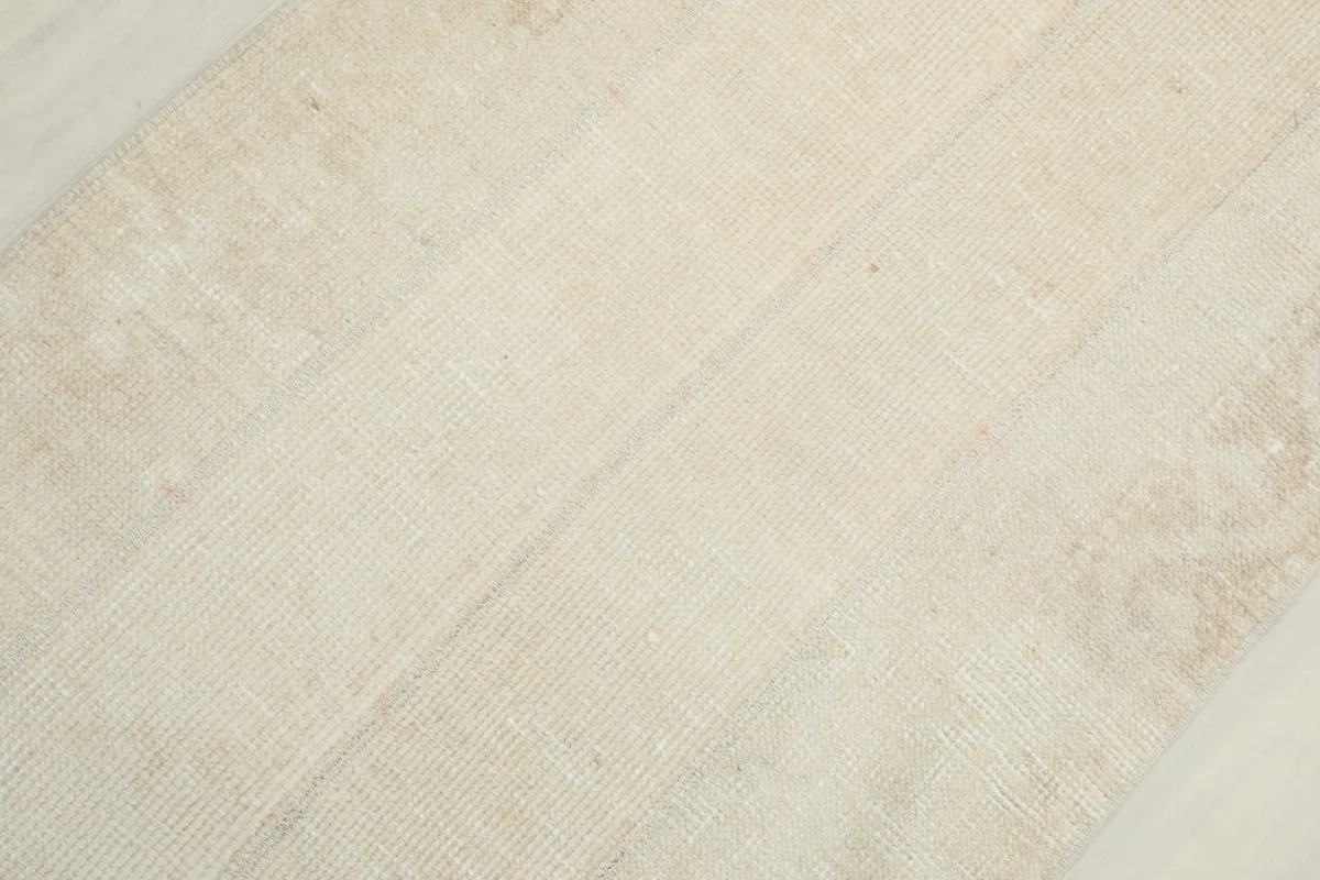 Diagonal view across the rug highlighting the low pile and distressed appearance