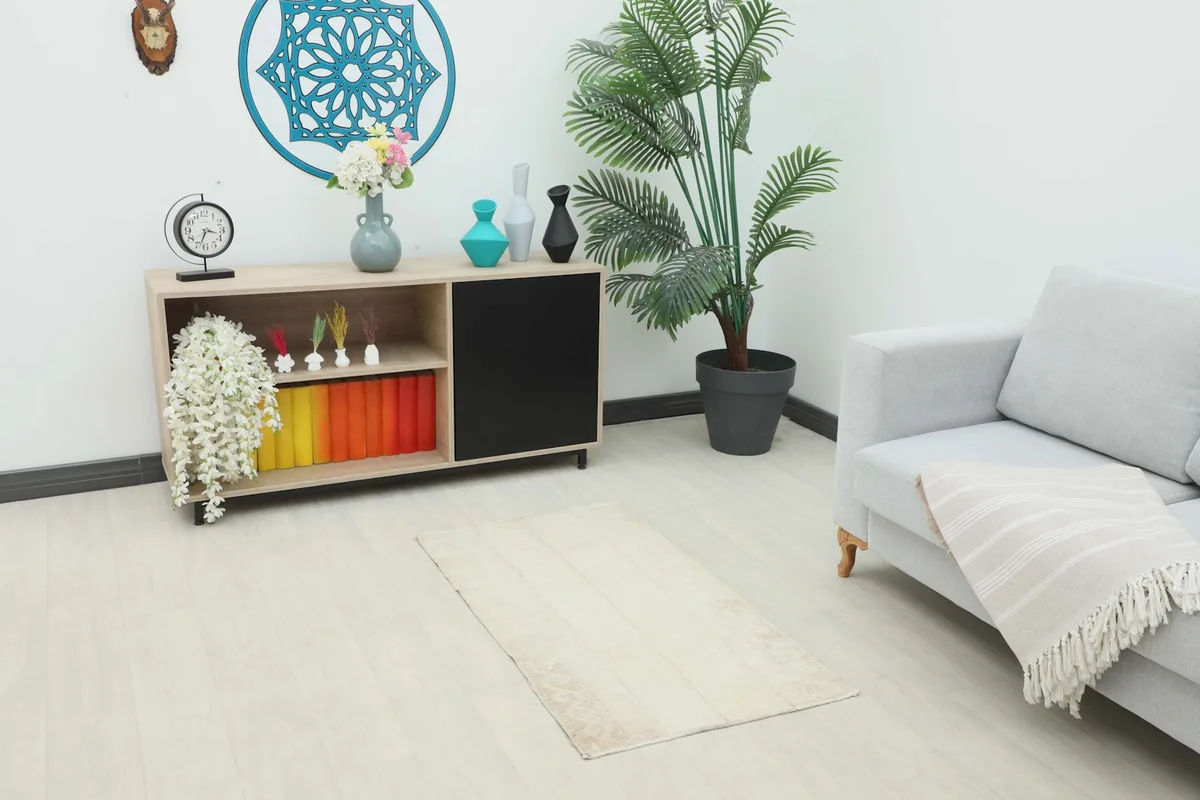 Ivory and beige vintage rug placed in a living room setting with modern furniture