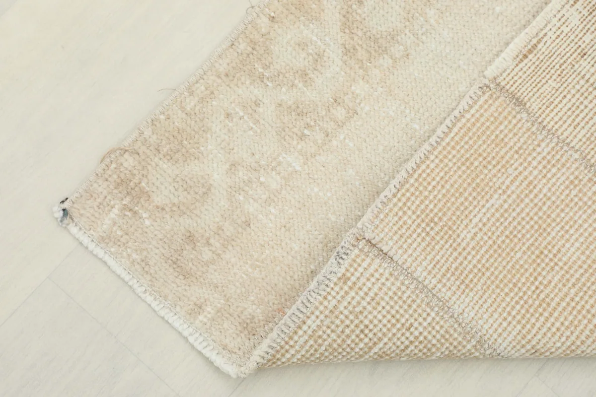 Corner view showing the reverse side of the rug, revealing the cotton foundation and knotting