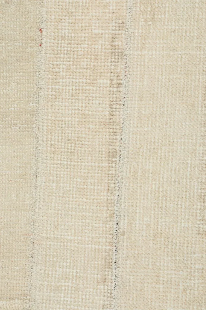 View of the rug's back, showing the cotton foundation and tight hand-knotting.