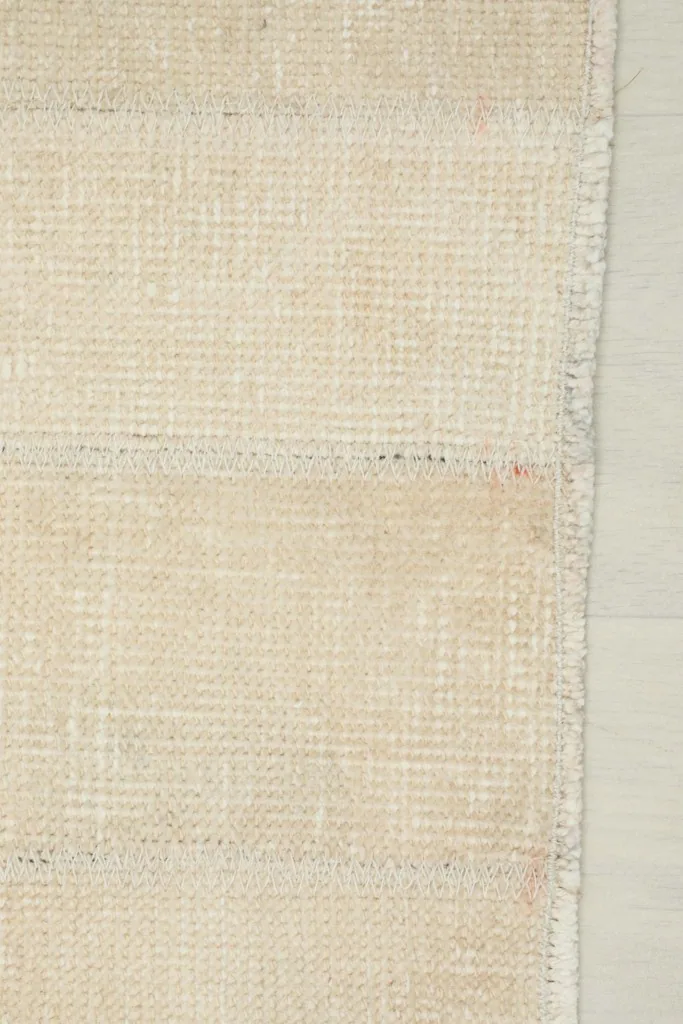 Close-up of the rug's back, revealing the intricate weaving of the cotton foundation.