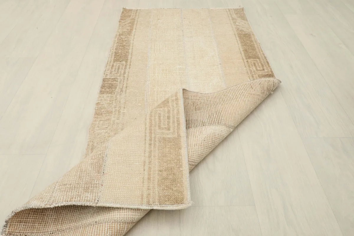 Rug partially folded, showcasing both the front design and the sturdy cotton foundation.