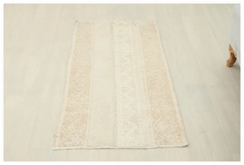 Full top view of the 1'10" x 3'7" ivory and beige geometric vintage Anatolian rug on a white background.
