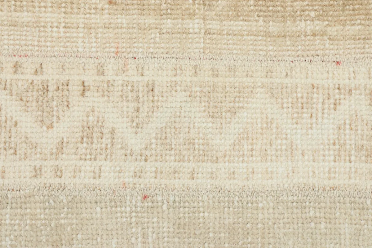 Macro view of the low wool pile, revealing the hand-knotted texture and soft colors.