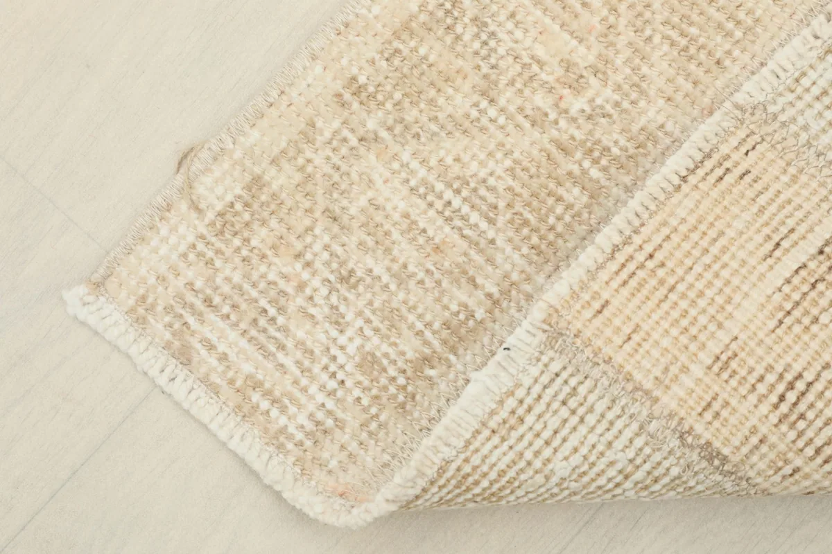 View of the underside of the rug, showing the cotton foundation and hand-knotted construction.