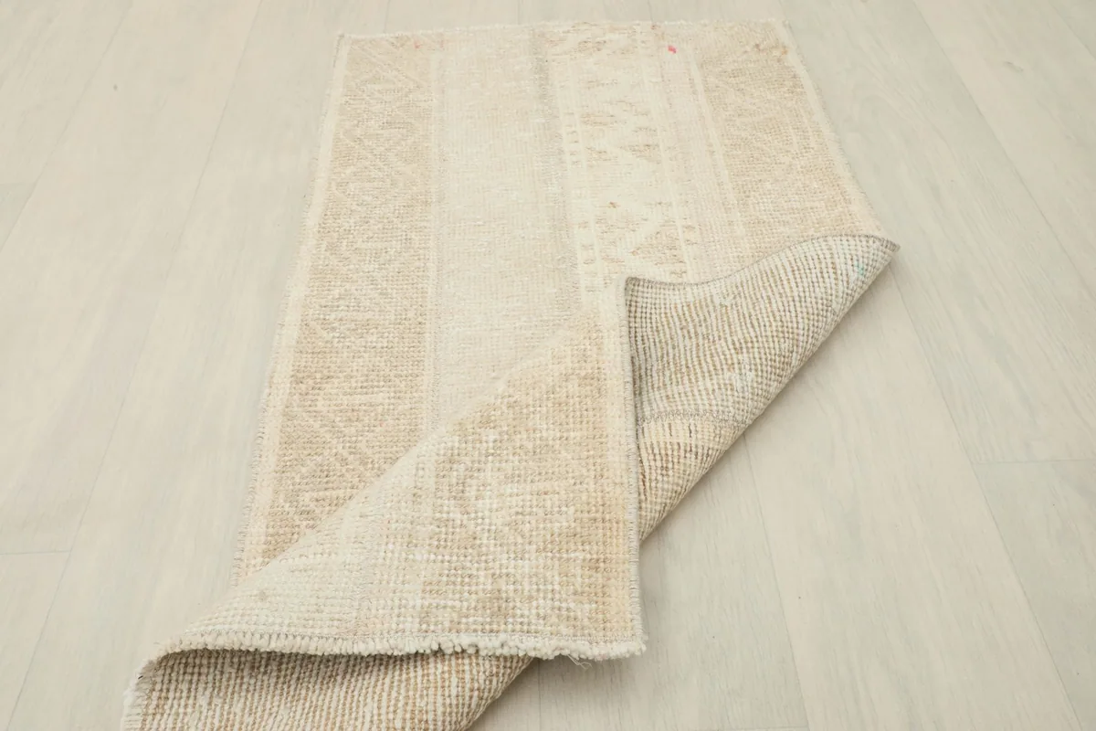 Corner of the rug folded back to reveal the density of the wool pile and cotton foundation.