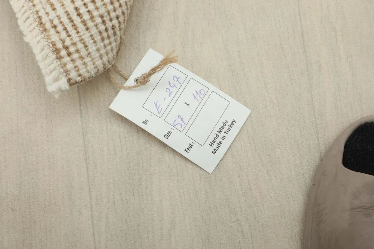 Tag displaying the rug's size 57 x 110 cm (1'10" x 3'7") and origin 'Made in Turkey'.
